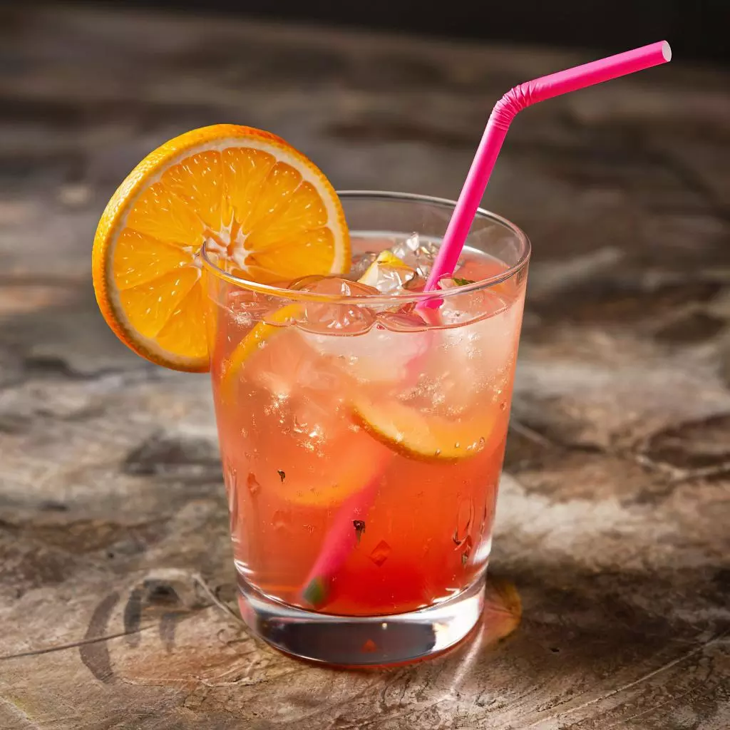Цветной коктейль Aperol Spritz с ломтиком апельсина и яркой трубочкой
